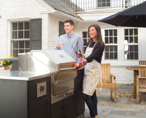 a couple enjoying their Memphis Built-In grill and outdoor kitchen