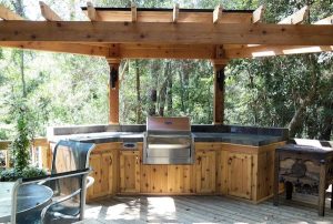 Outdoor kitchen with pergola and wooden cabinets